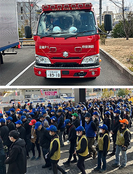 上の写真は吹田消防署の赤い消防車が駐車している様子。下の写真は青い帽子をかぶった多くの人々が整然と避難訓練を行っている様子で、商業施設周辺で実施されている。』